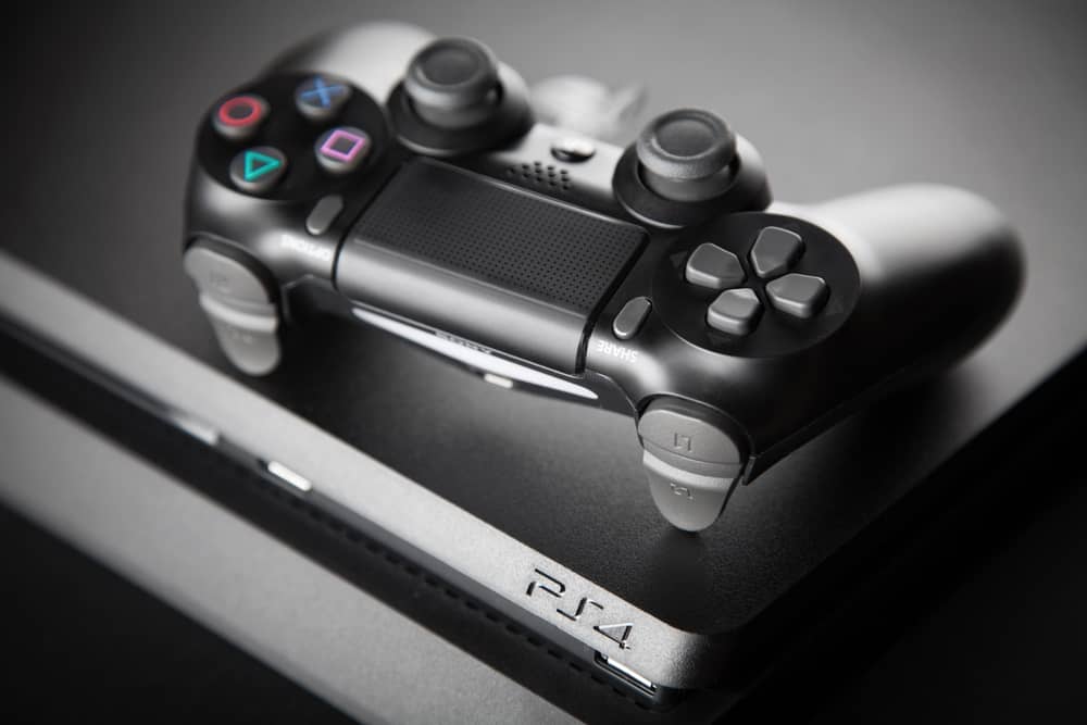 Manette de PS4 et sa console, sur laquelle nous expliquons comment supprimer un jeu.